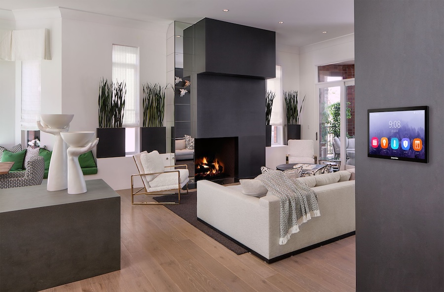 A modern living room with a Crestron wall panel.