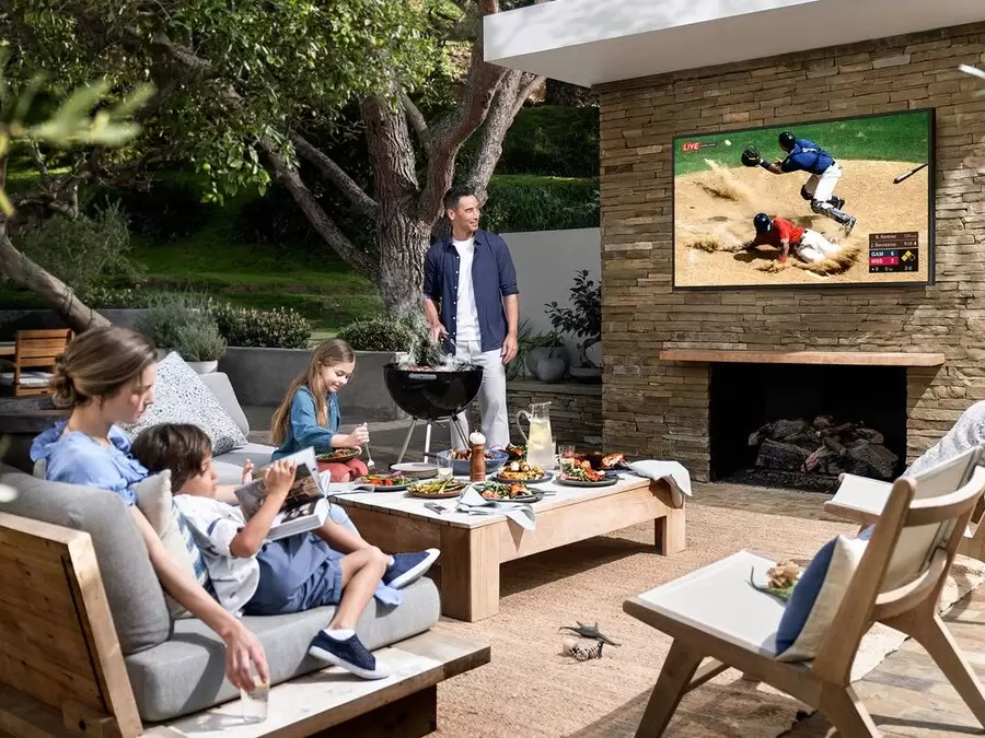 A backyard’s patio setup featuring a mounted Samsung Terrace outdoor TV