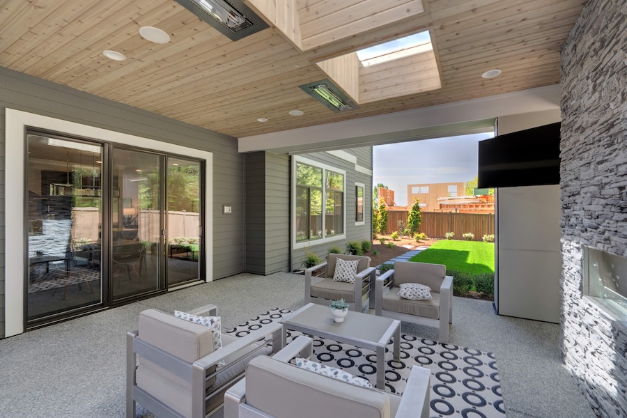 A covered outdoor patio with seating, TV, and skylights.