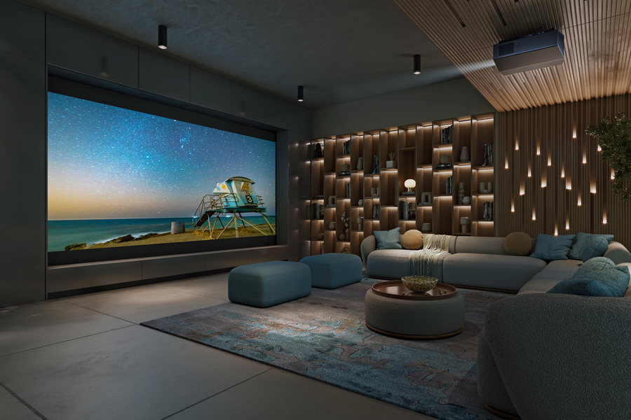 A home theater with a sectional, large screen, Sony projector, and beautiful lighting.