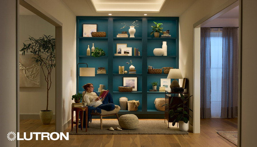 Cozy reading nook with Lutron lighting, featuring a blue built-in bookshelf, warm accent lights, and a relaxed seating area