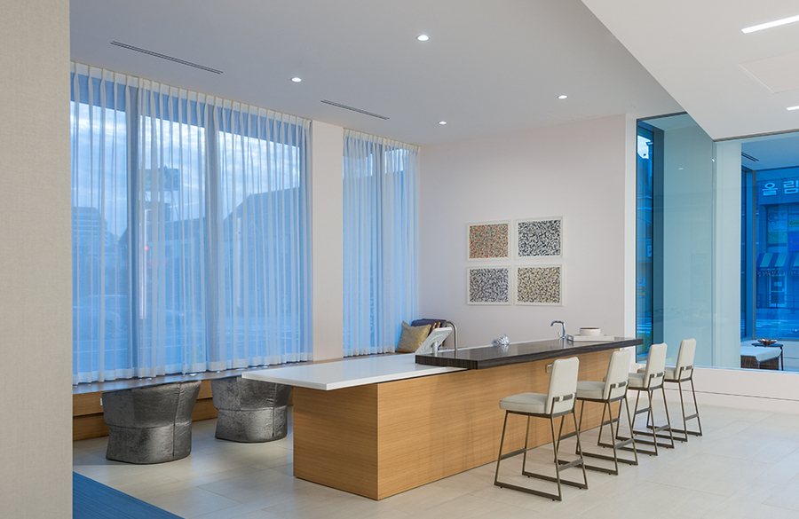 A modern office with DMF lighting and a touchscreen on a counter.